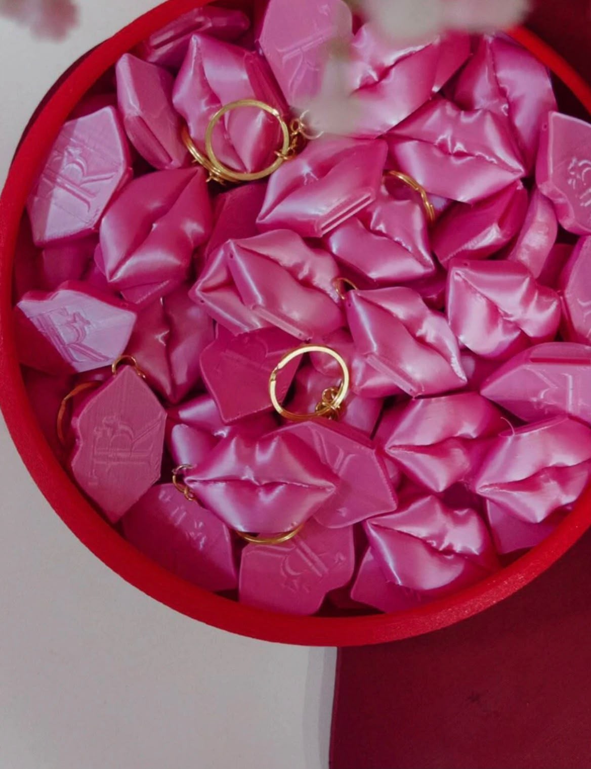 Pink lip-shaped can opener keychains with a custom logo