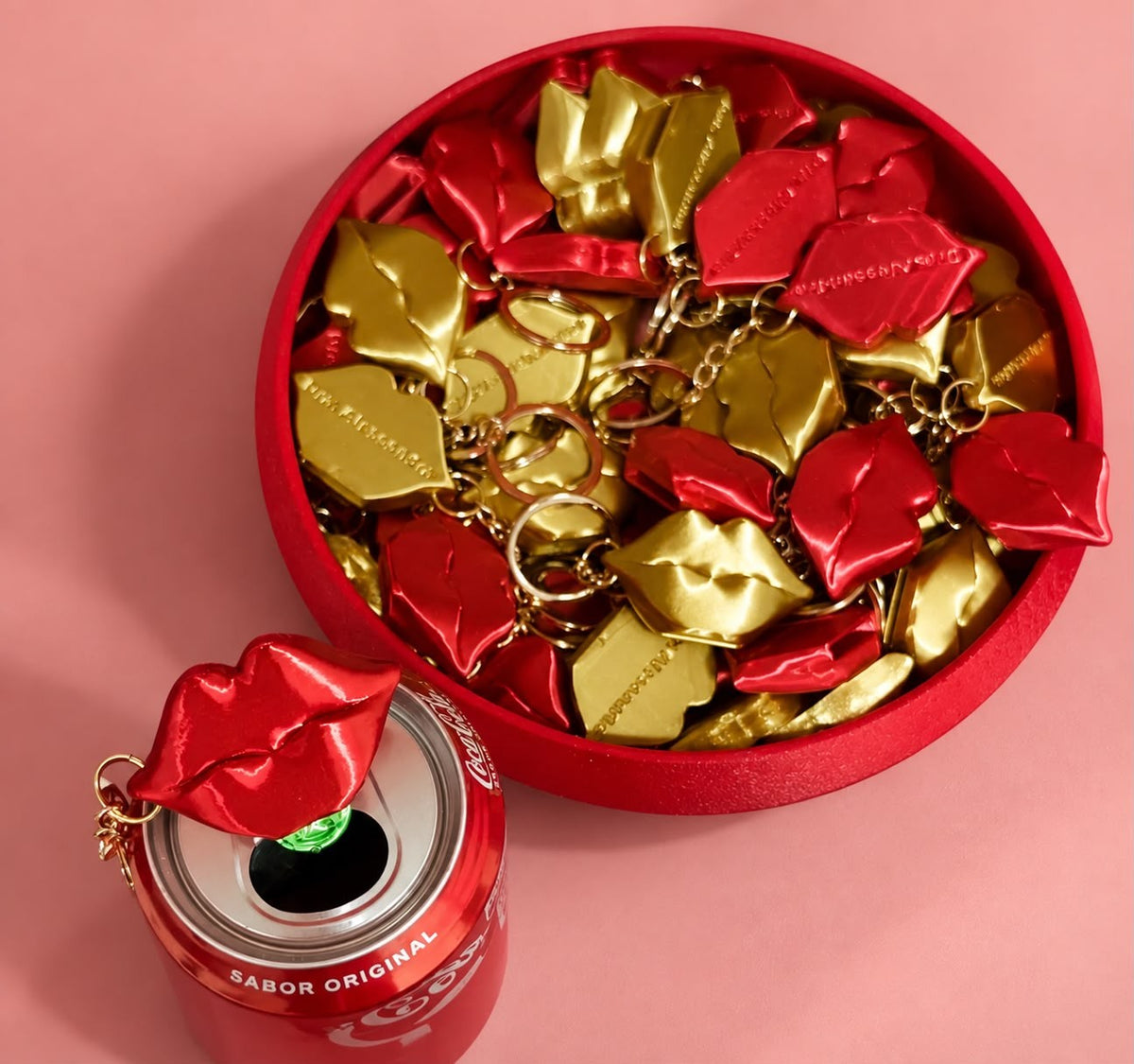 Red and gold lip can opener keychains, one on an open can