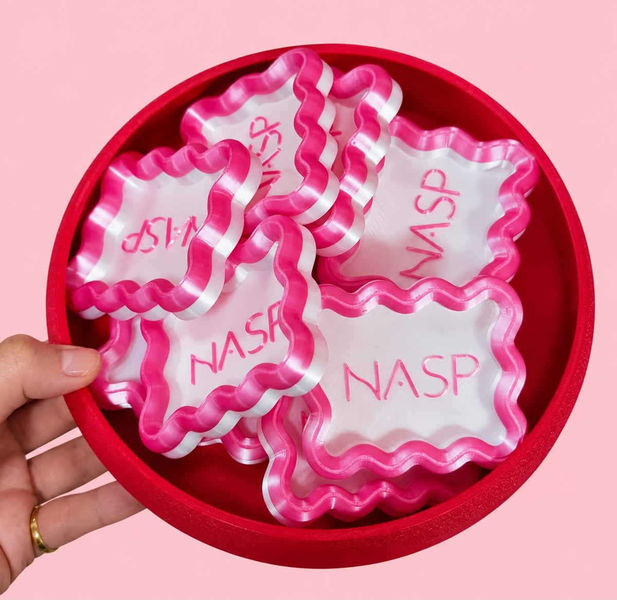 Bowl of pink wavy jewellery trays with a custom logo